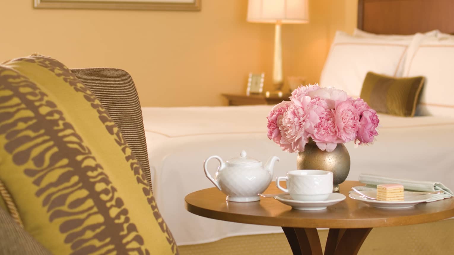 Terrace City-View Room close-up of white teapot, cup, gold vase with pink flowers on beside table