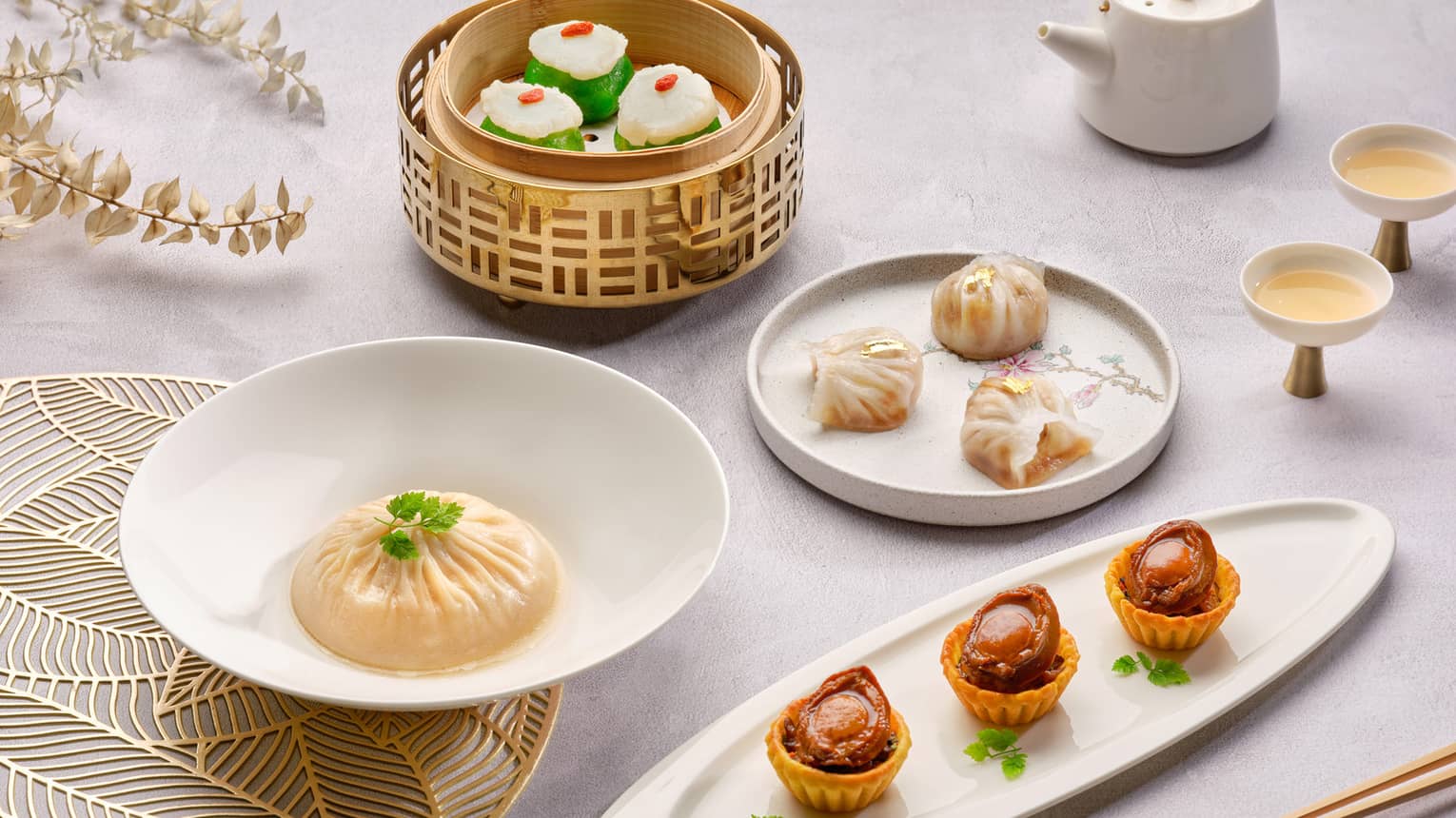 ,Several small savory food dishes served with a pot of tea