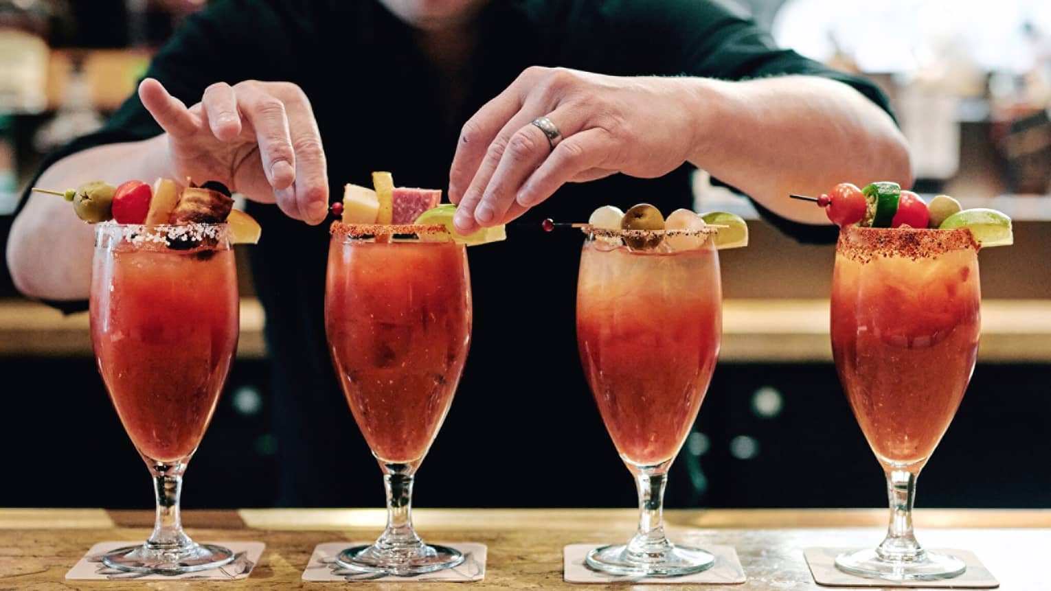 A row of four Bloody Marry’s being garnished.
