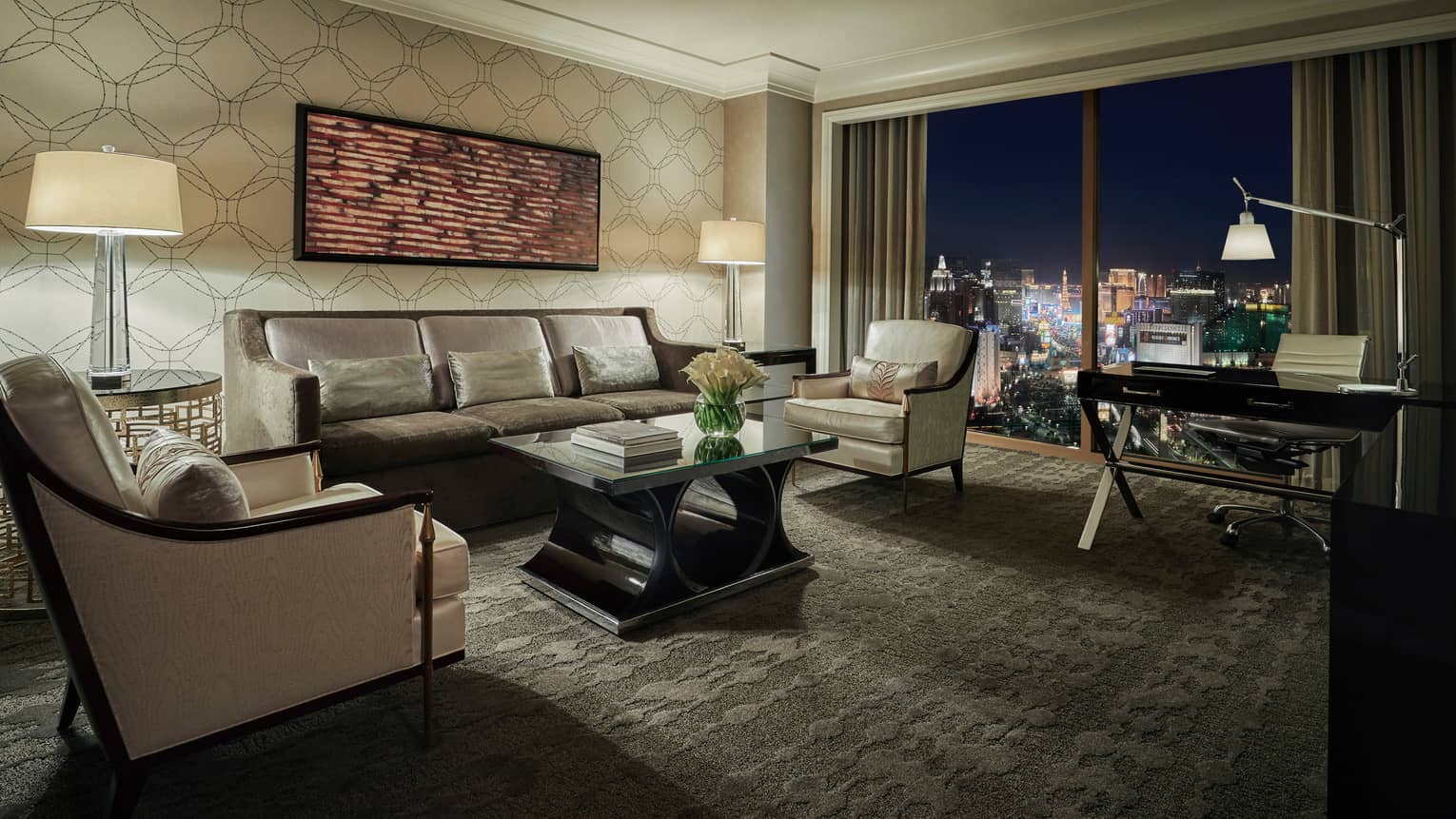 Strip-View Suite carpeted living room, desk by window overlooking Las Vegas strip lights
