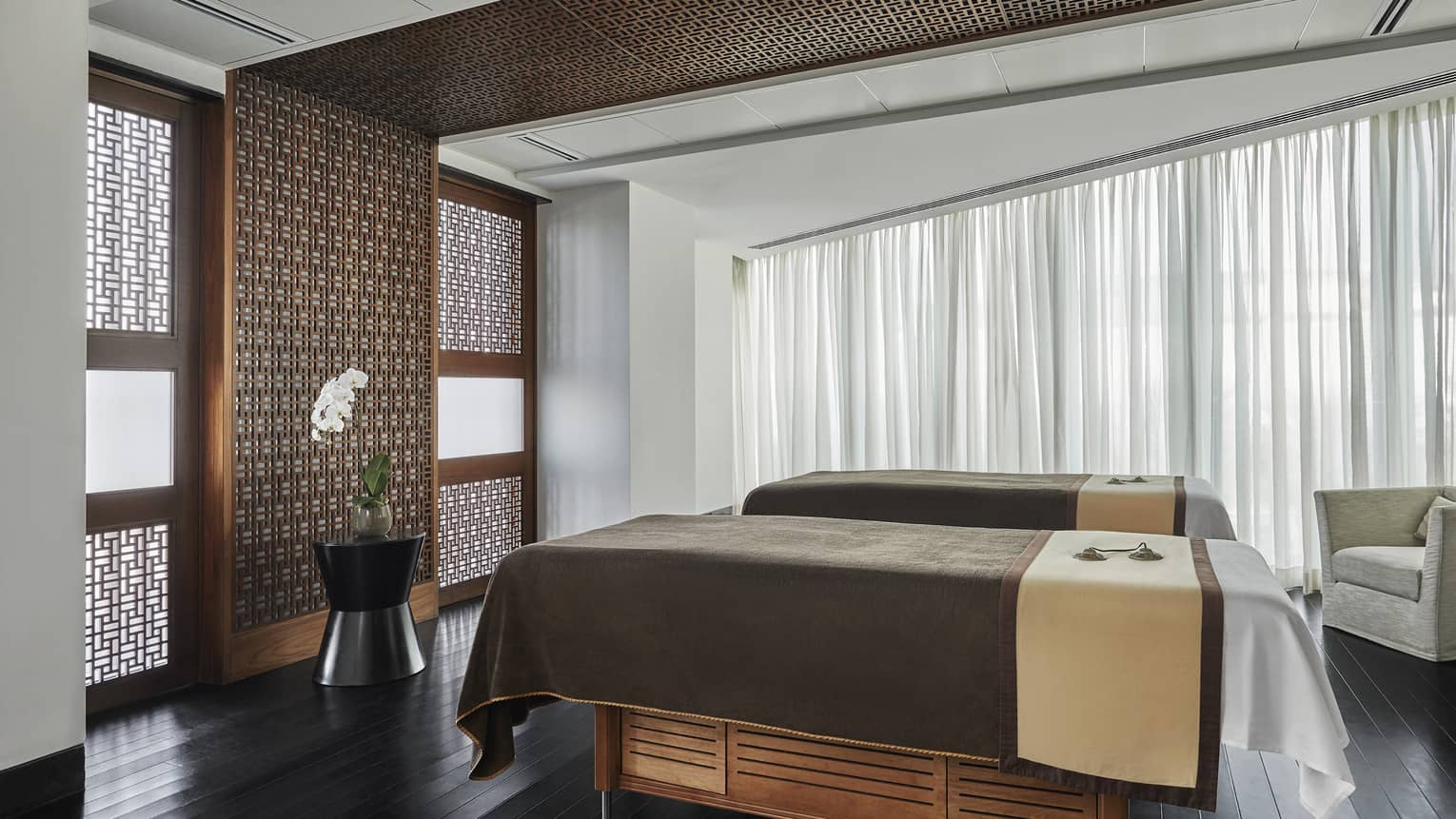 Pearl Spa side by side couples massage beds in treatment room with wood accent walls