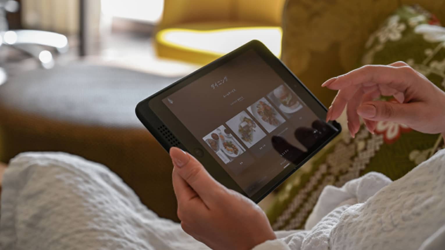 Guest using an in-room tablet to browse dining options