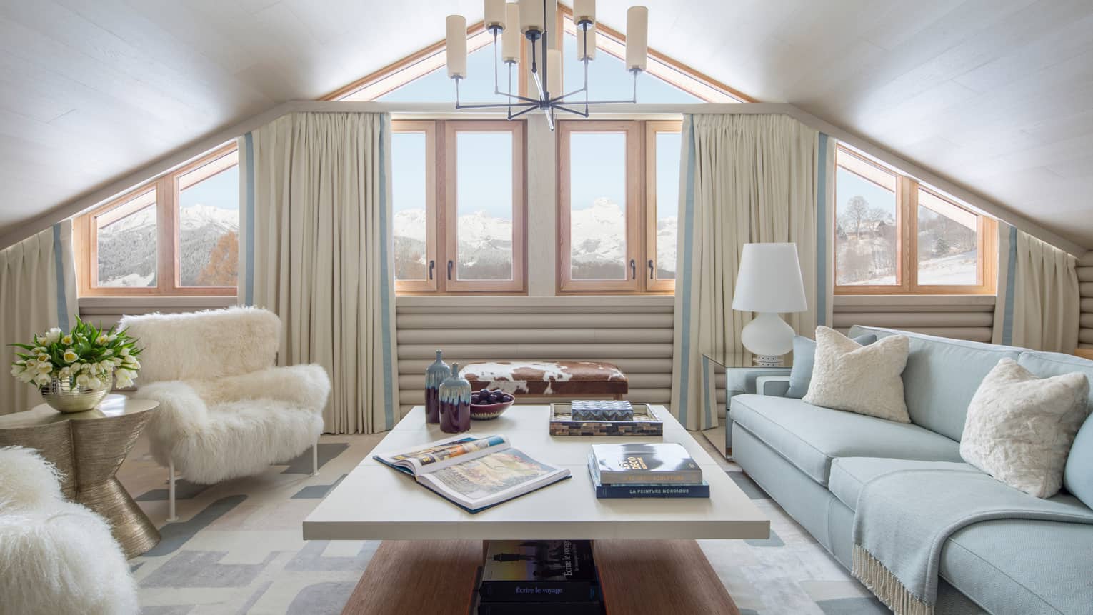 Suite Mont D'Arbois chandelier, windows under gable roof, white sofa, faux fur armchairs