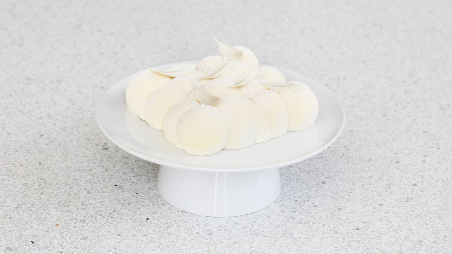 A white cake in the shape of a cloud.
