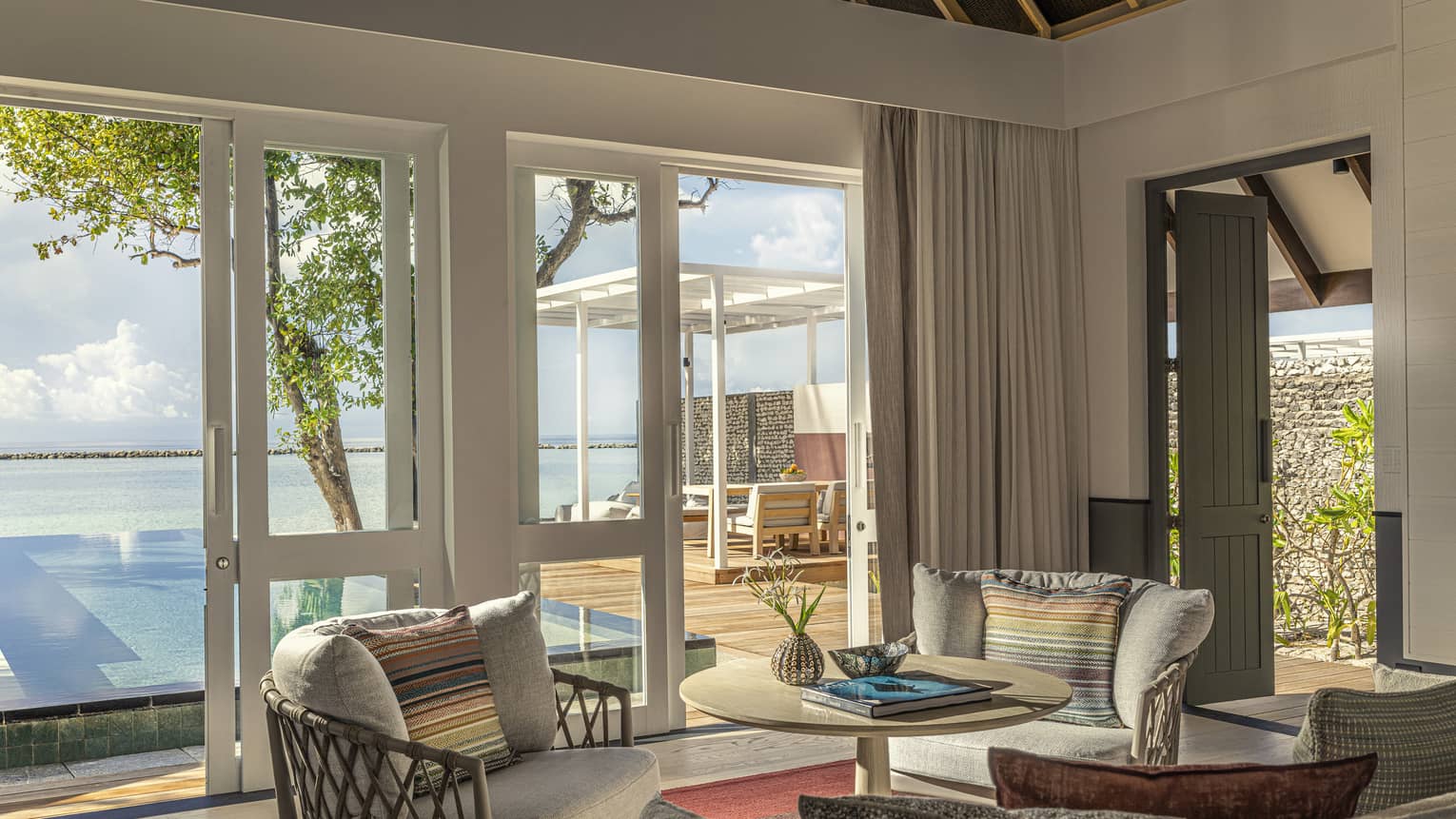 Private villa living room, with doors to a private pool deck and ocean view