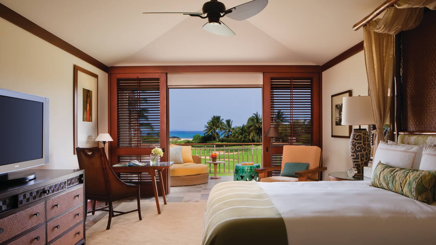 Ocean Golf-View Room side of bed by dresser, TV, desk by open wood patio shutters