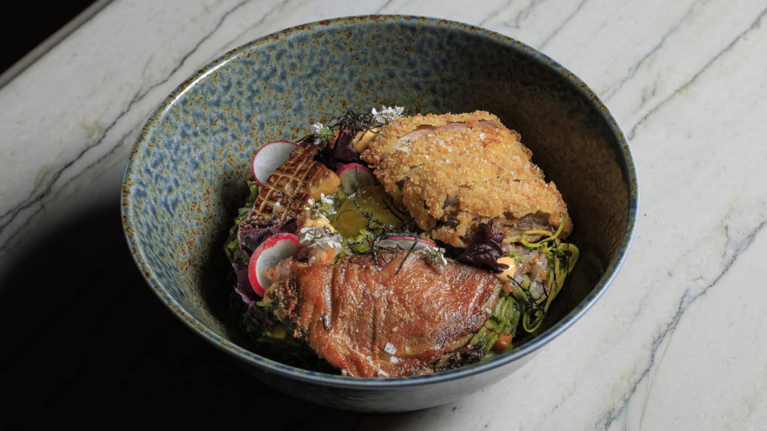 Arroz Con Pato made with cilantro rice, yuzu, confit, kamo katsu, foie gras, shoyu egg yolk and carrots, served in a stoneware bowl