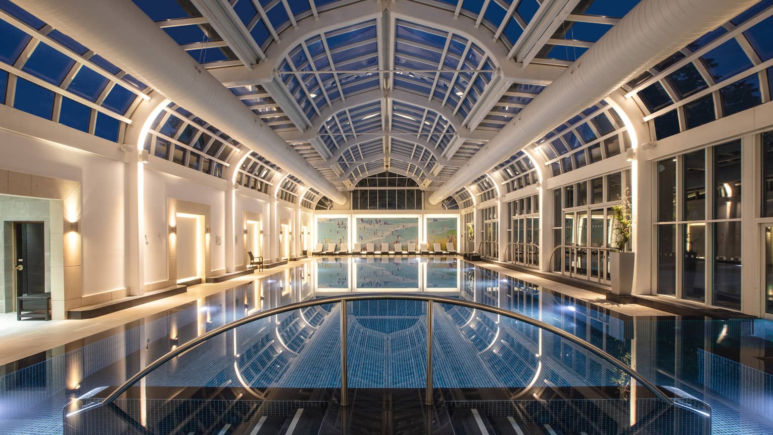 Deep blue indoor spa pool illuminated under skylight night view