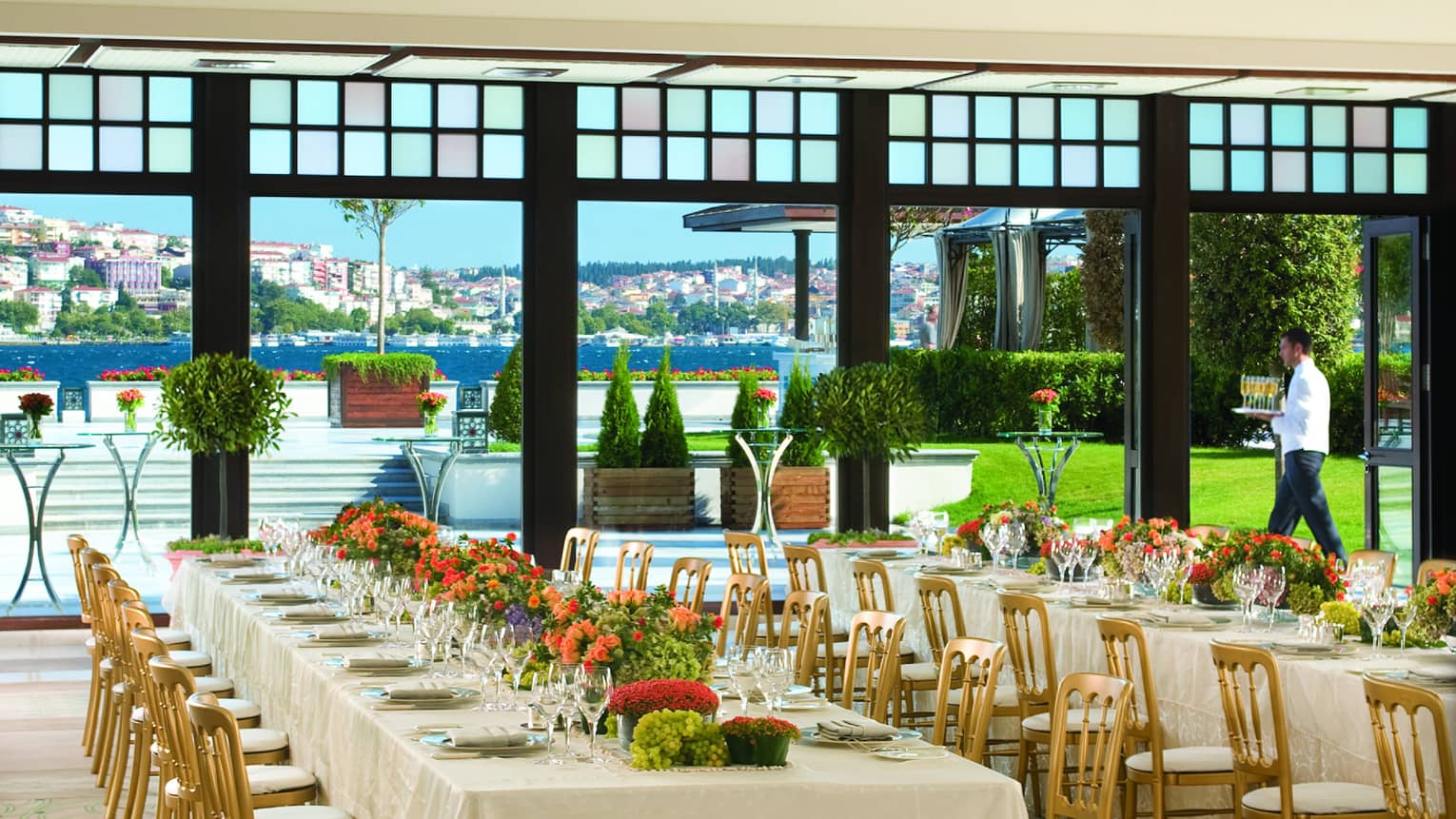 Bosphorus Ballroom long banquet tables with gold chairs under chandeliers, near open wall to terrace