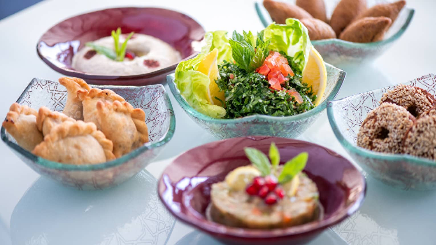 Several bowls filled with fried goods and vegetables.