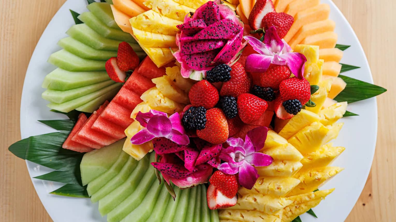 Plate of many different vibrantly colourful fruits