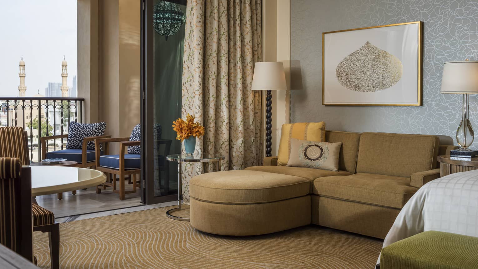 Hotel room with brown sofa and walk-out balcony
