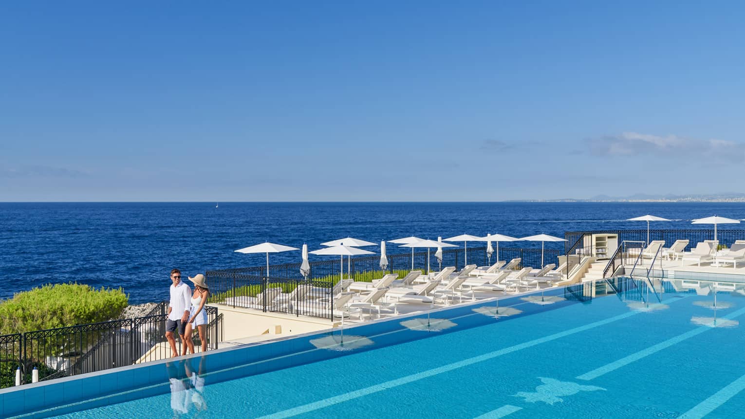 A couple walking around a luxury hotel pool