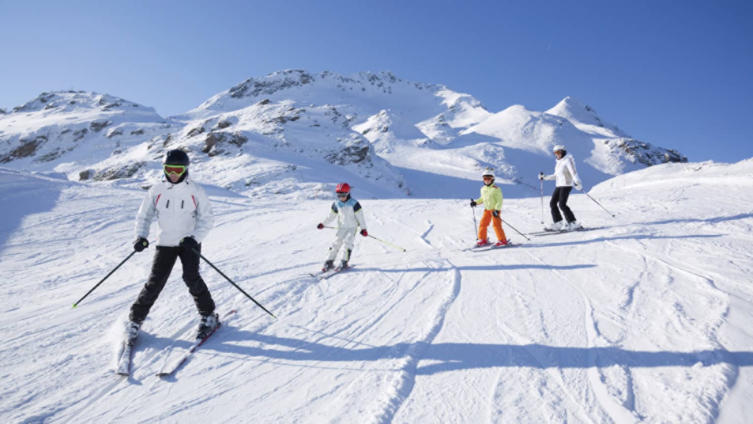 Family skis down snowy mountain