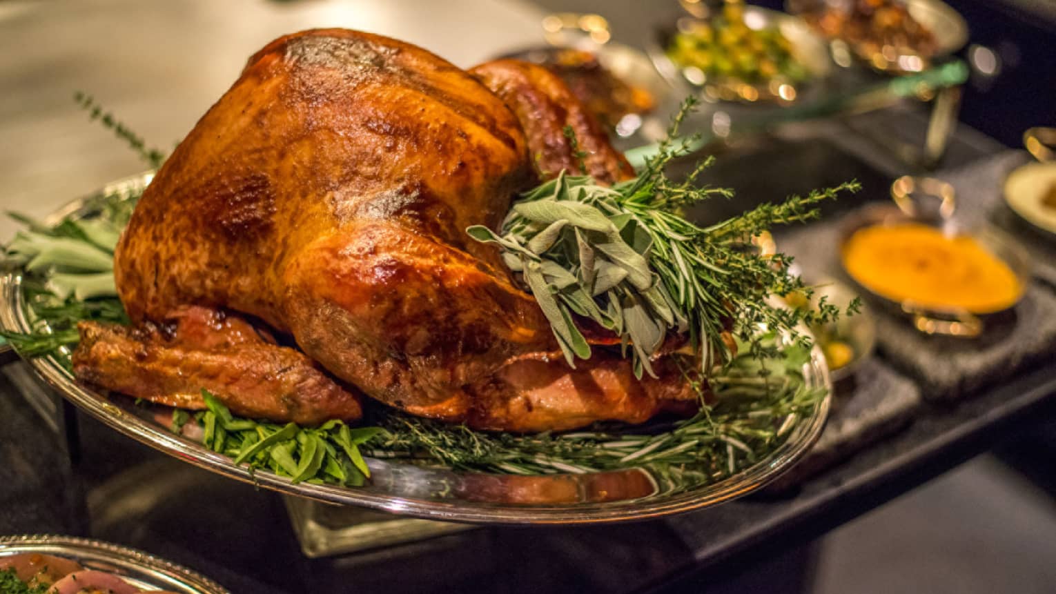 Roast turkey with fresh herbs on silver platter