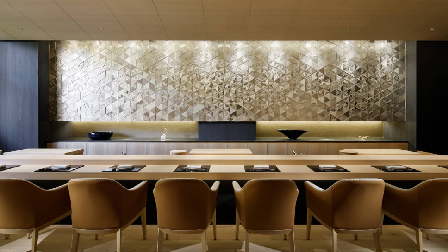 Sushi Wakon large chairs line light wood bar under silver tile wall