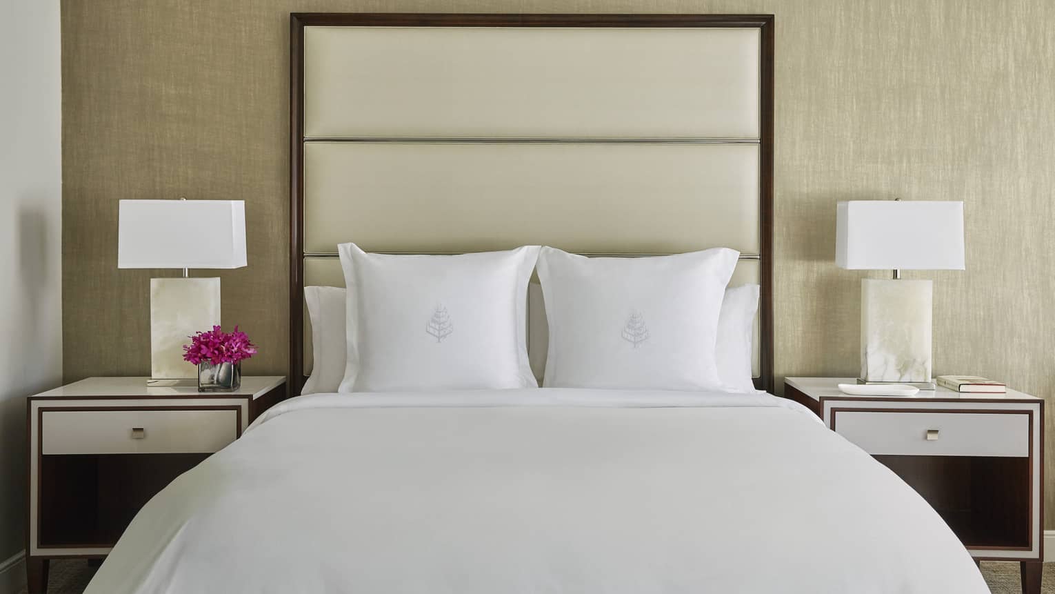 Deluxe Accessible Room head-on view of bed with white linens, tall padded beige headboard, nightstands with lamps