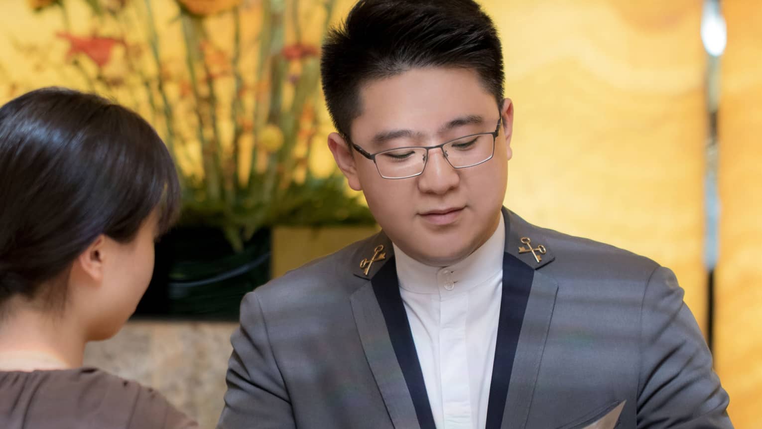 A concierge assists a guest at a marble desk