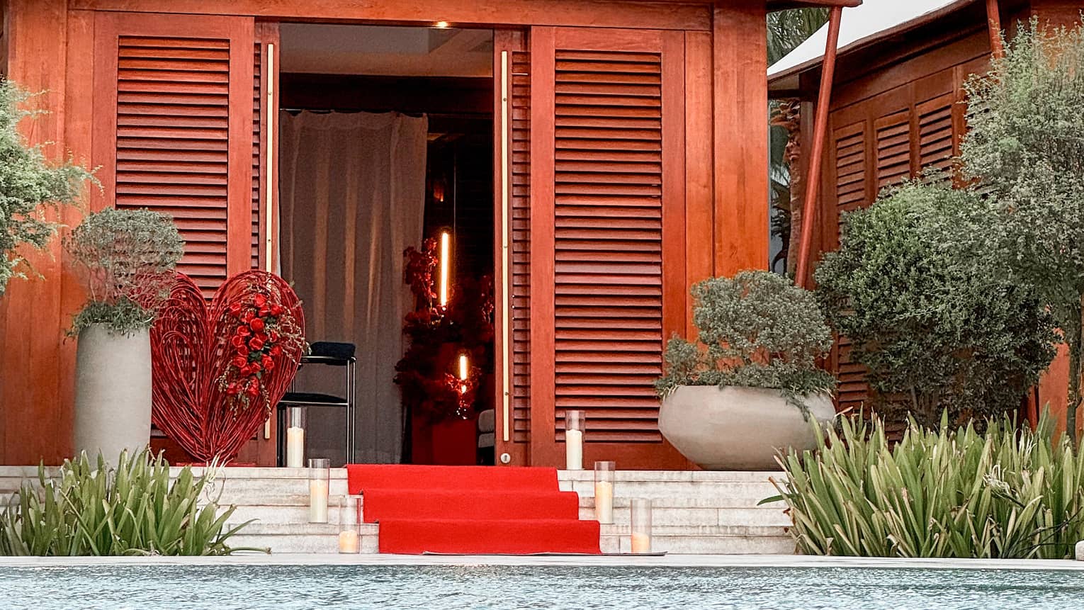 Poolside cabana with red carpet leading up to the entrance