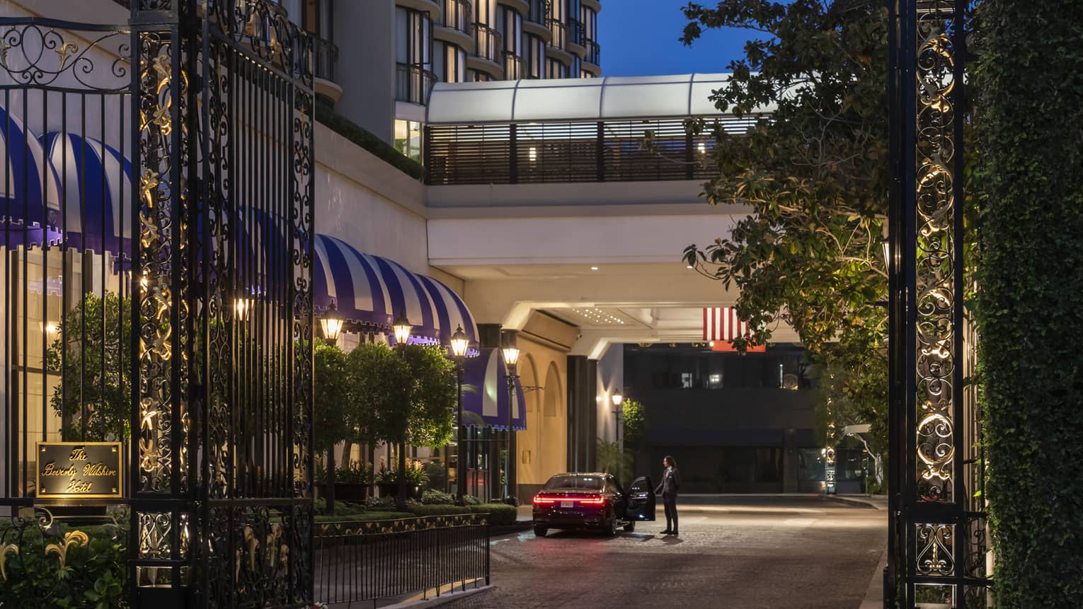 A gate with a golden symbol on top leading to a hotel.