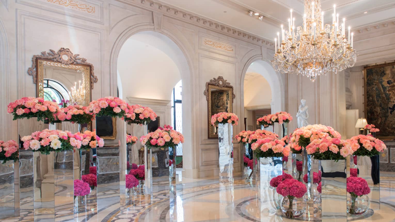 Four Seasons Hotel Paris marble lobby with gleaming floors, large pink floral arrangements