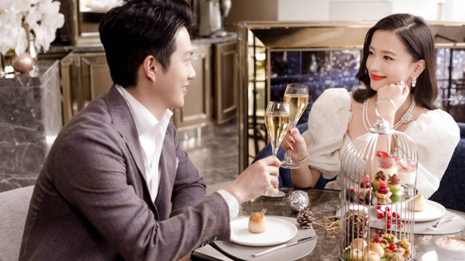 Smiling couple toasts during holiday afternoon tea at The Gallery
