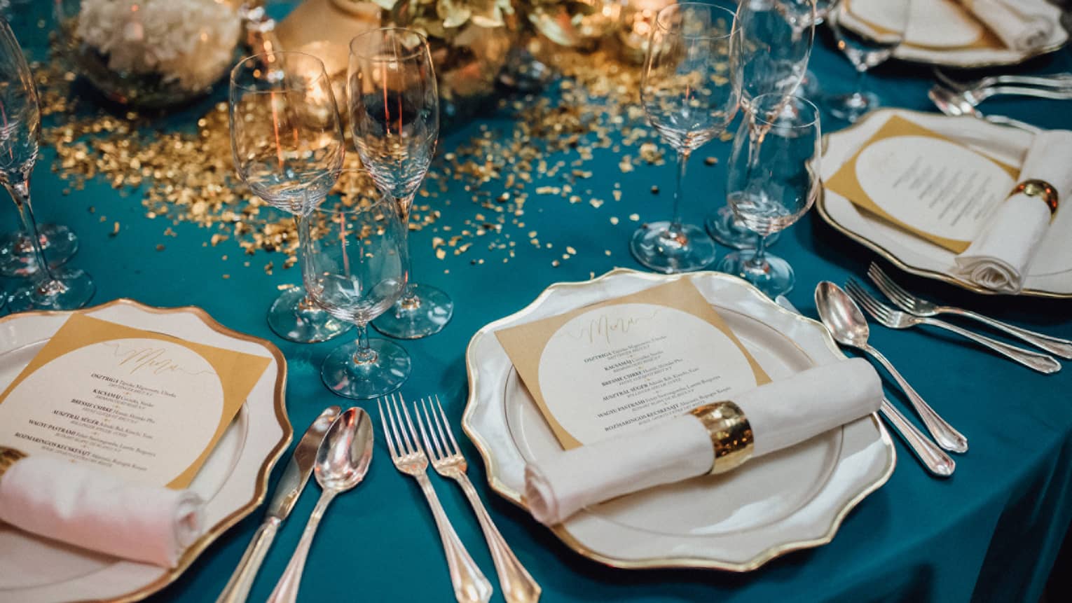 Elegant wedding banquet dining table, place settings with menus and gold accents