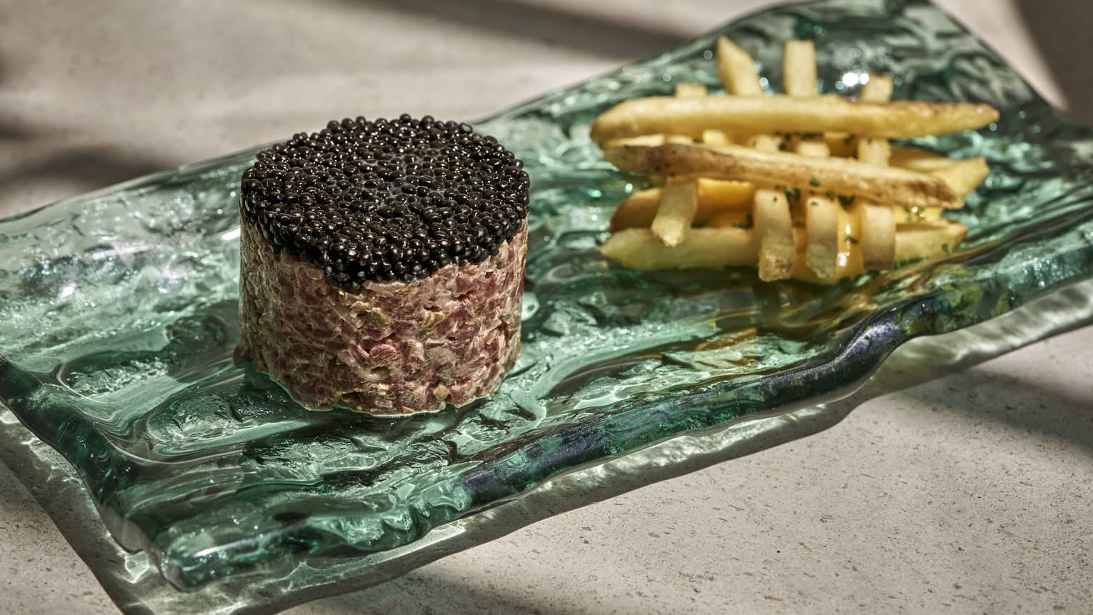 Turquoise glass plate with french fries and molded caviar