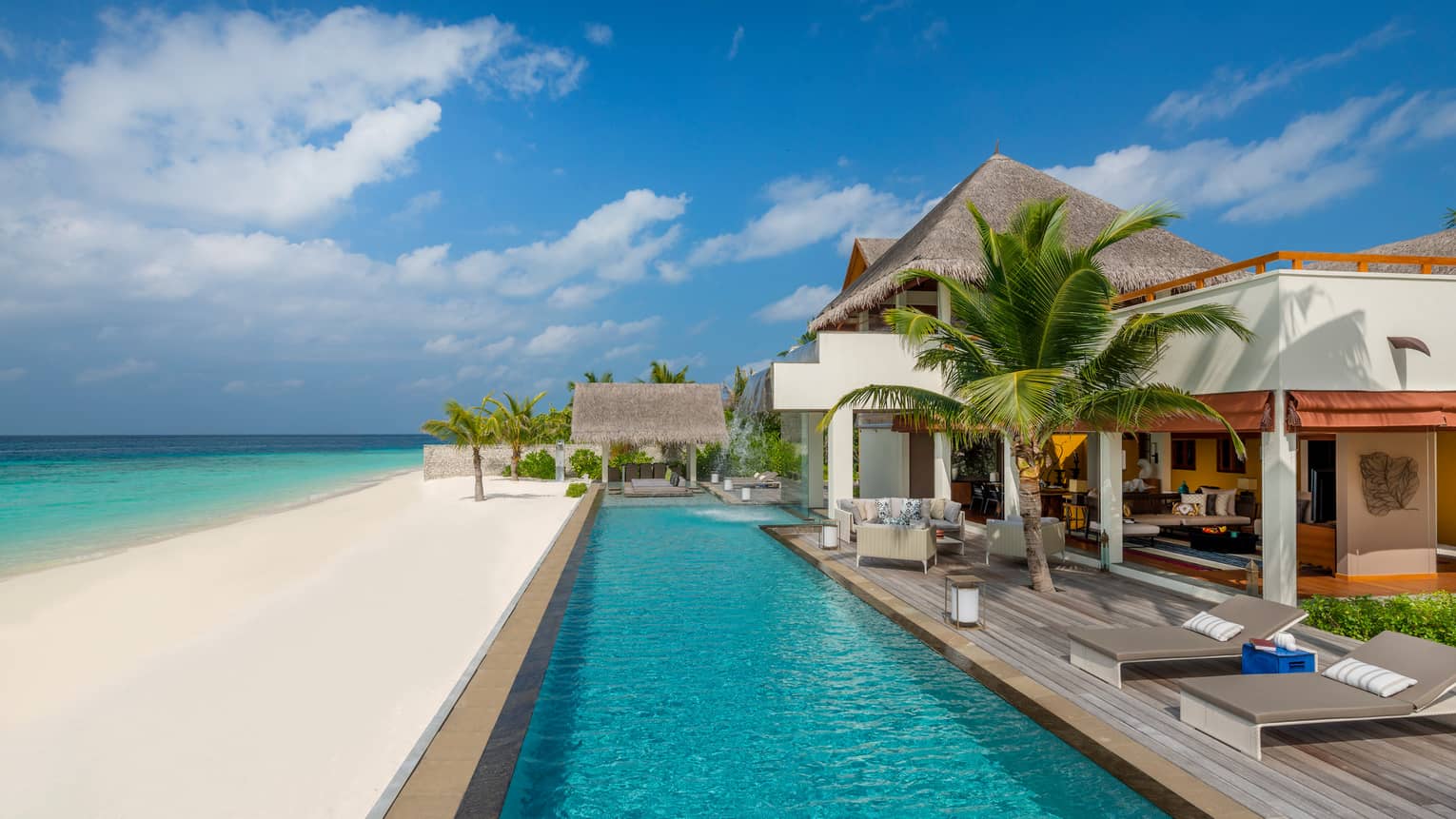 Three-Bedroom Landaa Estate villa deck by long swimming pool, white sand beach and ocean