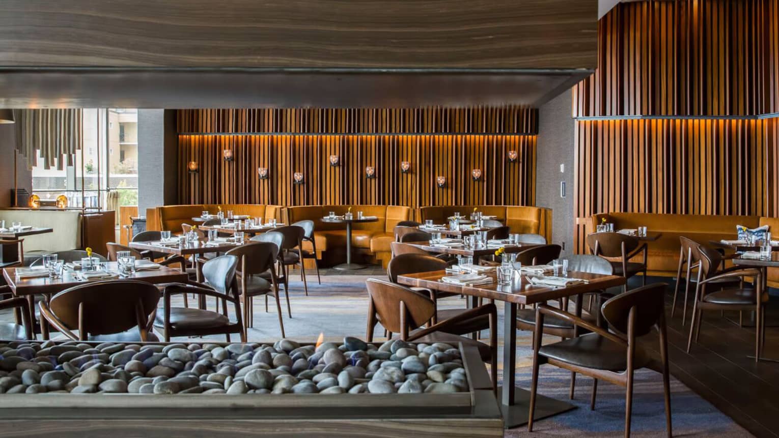 Goldfinch Tavern dining room beyond modern wood-and-stone gas fireplace