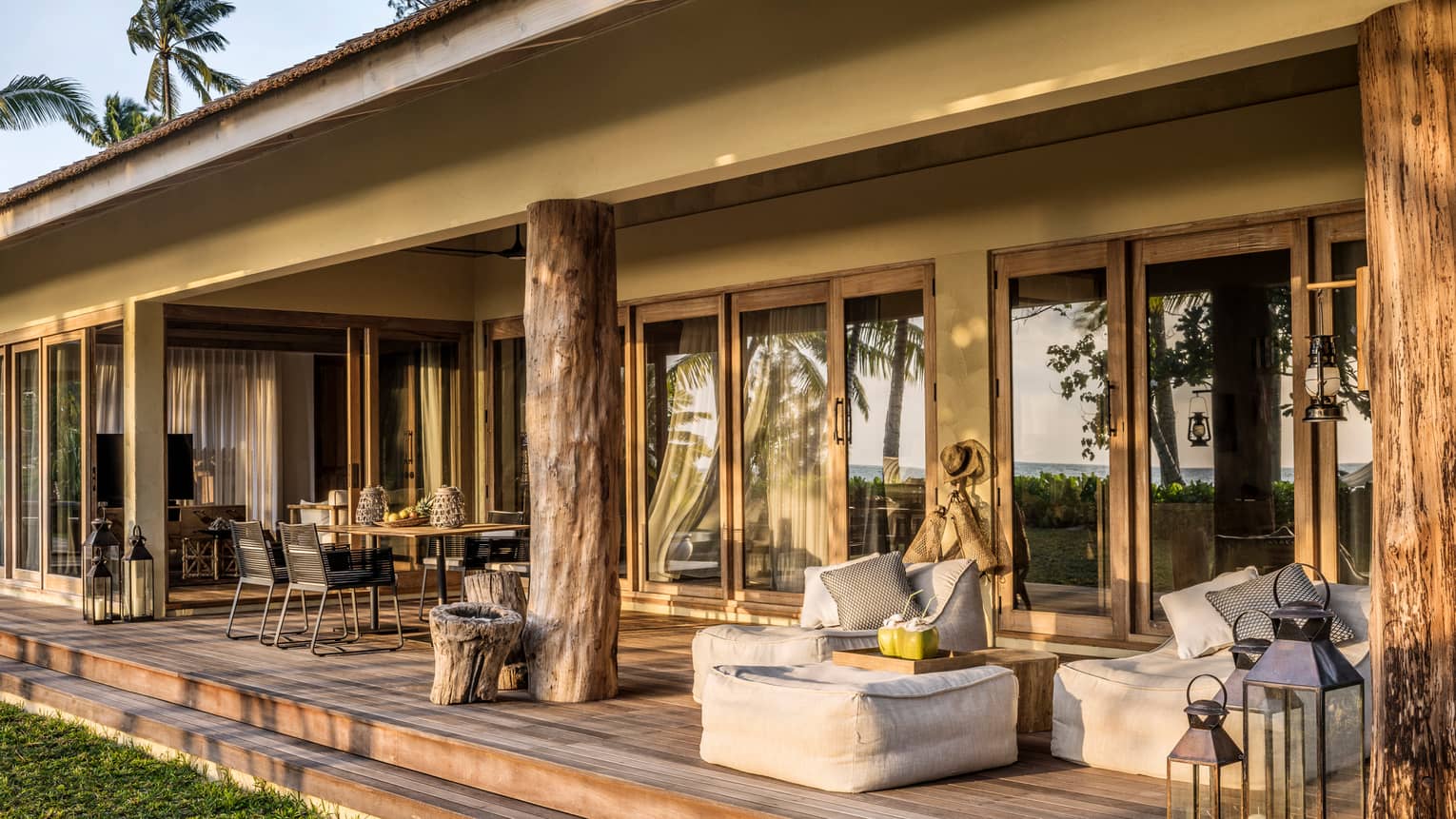 One-Bedroom Suite patio with large rustic wood pillars, cushions, dining table