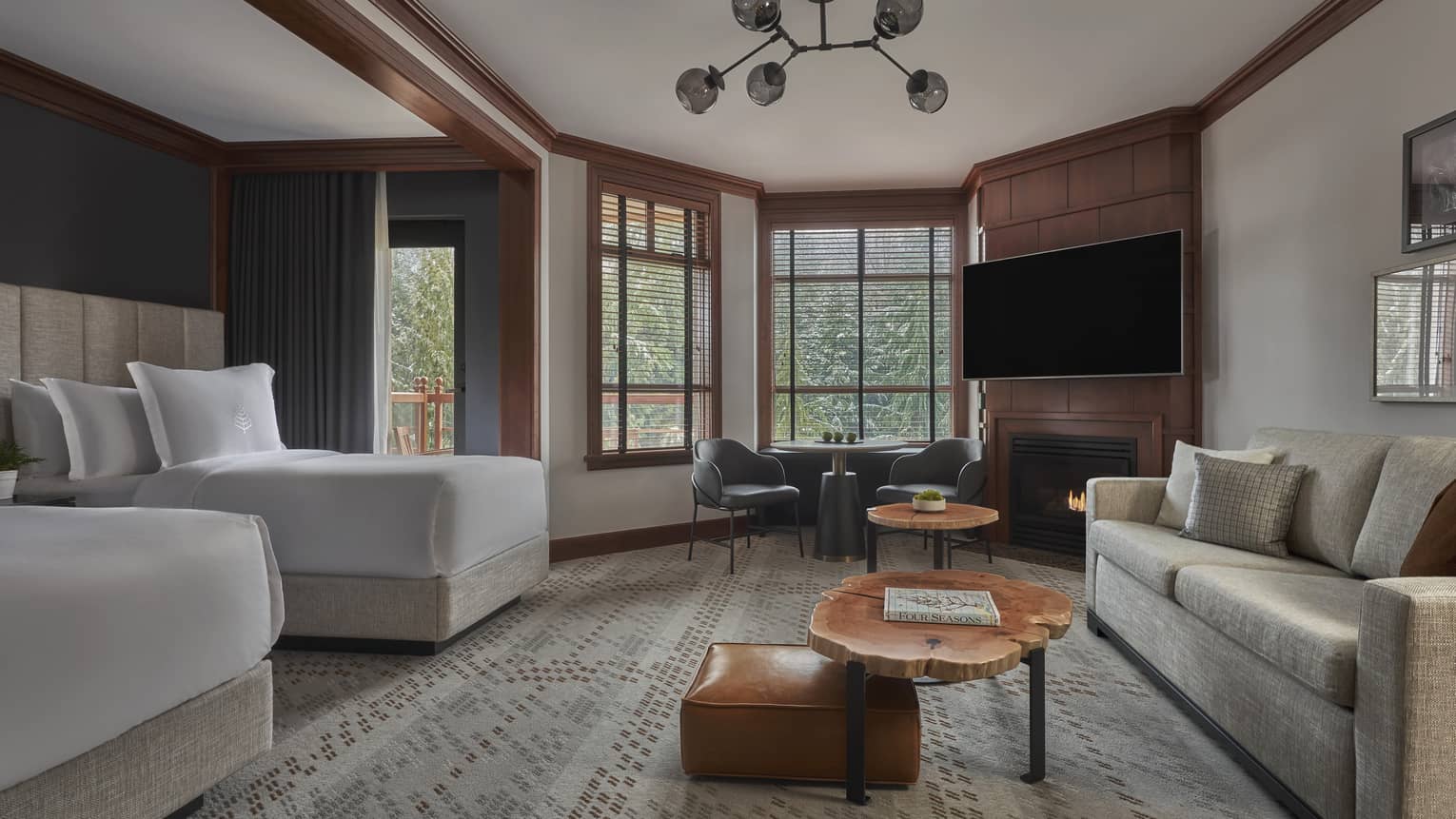 Room with two beds and a living area with a sofa and wooden coffee table
