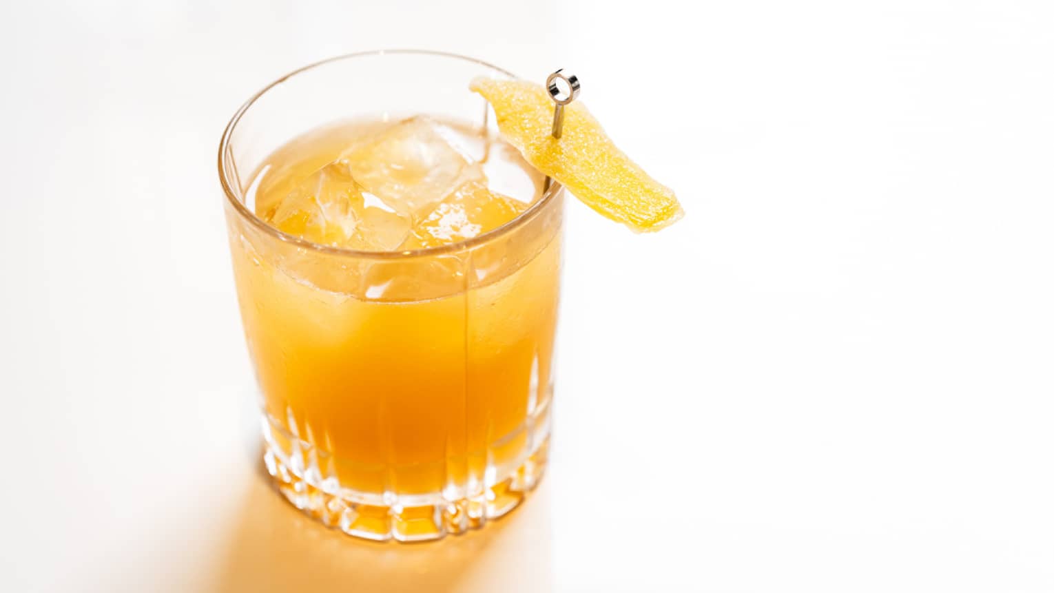 An orange coloured cocktail in a small glass.