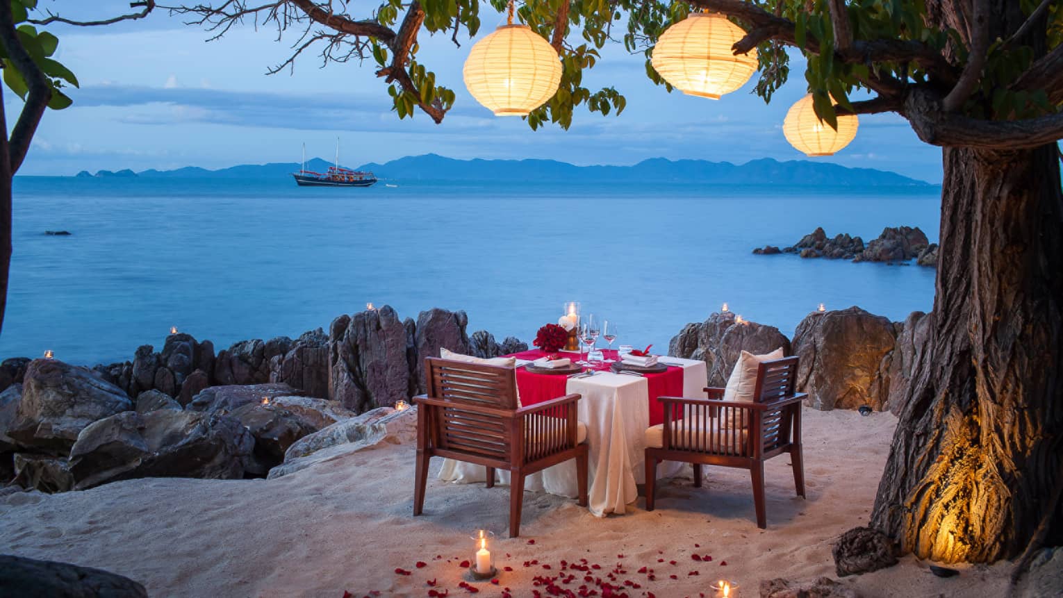 Private dining setting on the beach with a view of the Gulf of Thailand