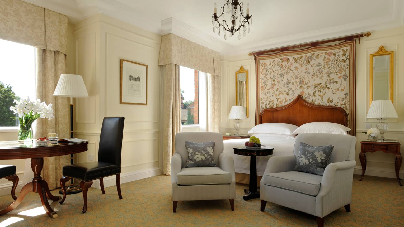 Heritage Room, two armchairs at foot of bed with floral headboard, desk by window