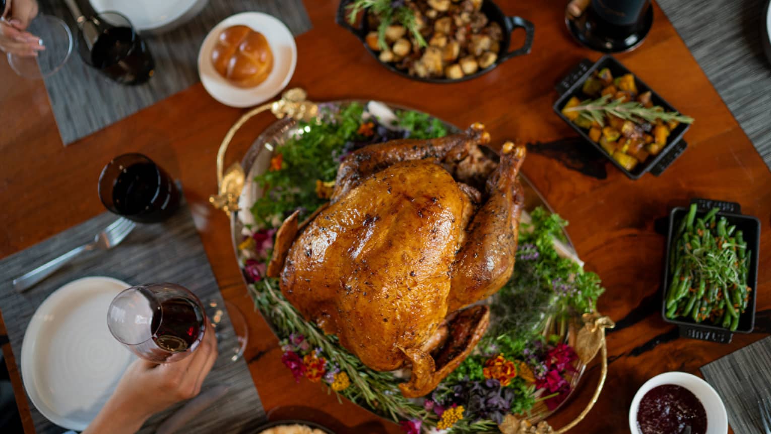 A cooked turkey surrounded by Thanksgiving dishes.
