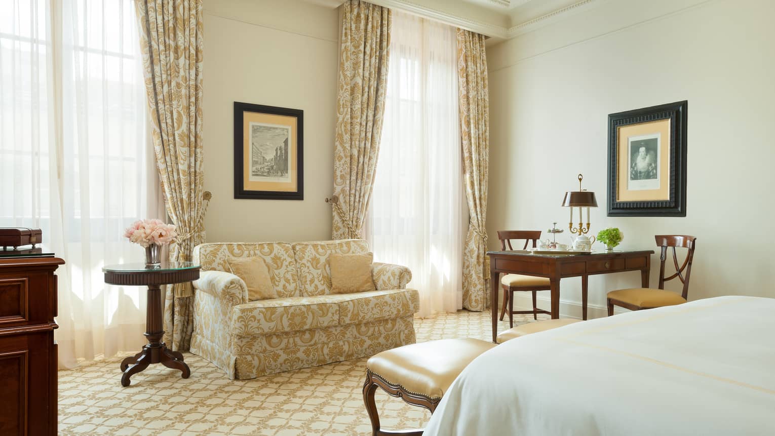 Deluxe room antique-style floral gold loveseat, curtains by sunny windows desk, bench, bed