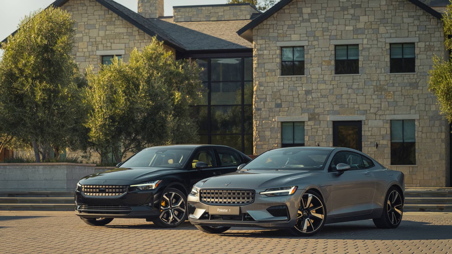 Two cars in front of a large stone and brick building.