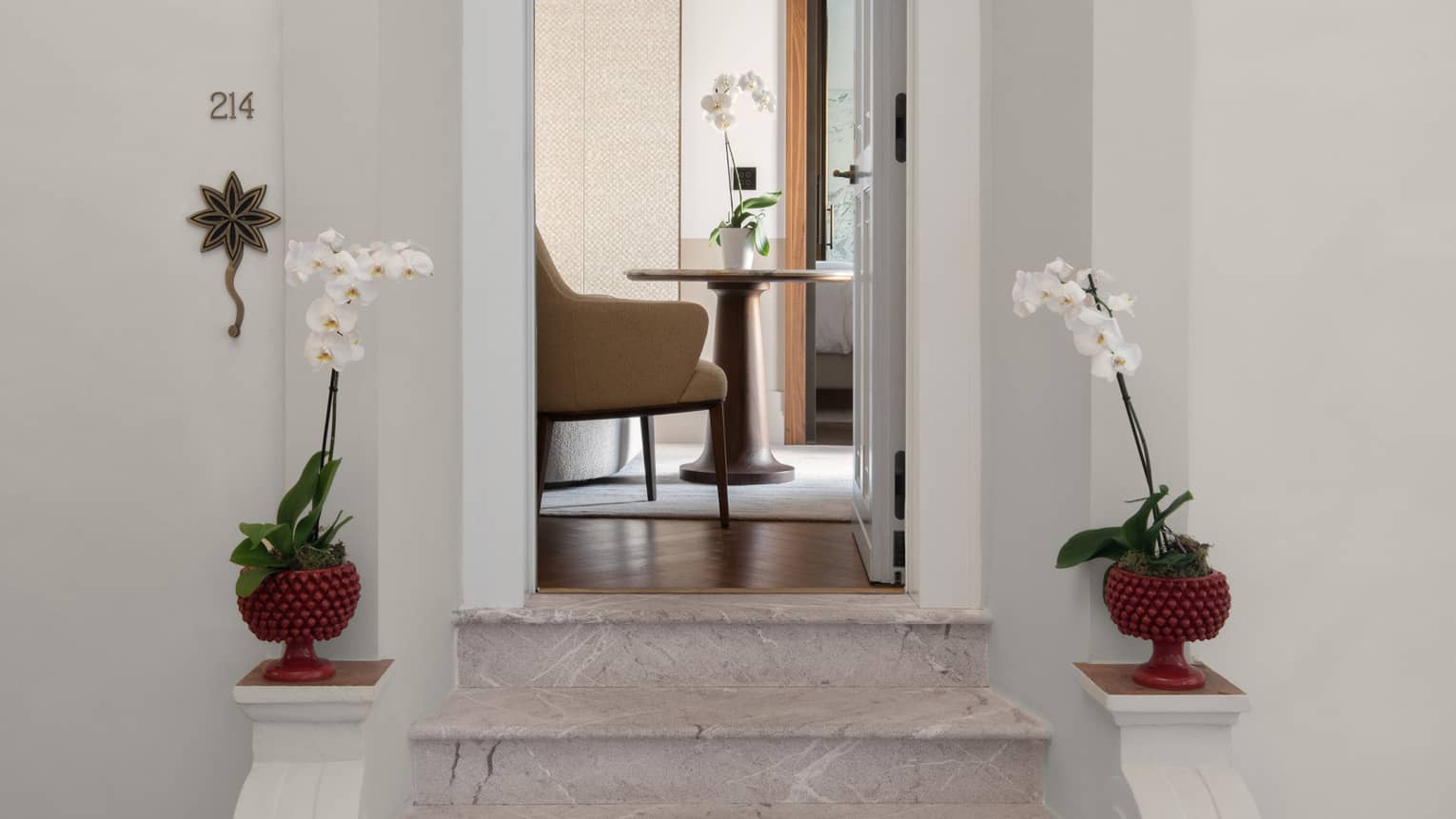 Small stairs leading up to a room with a chair and table.