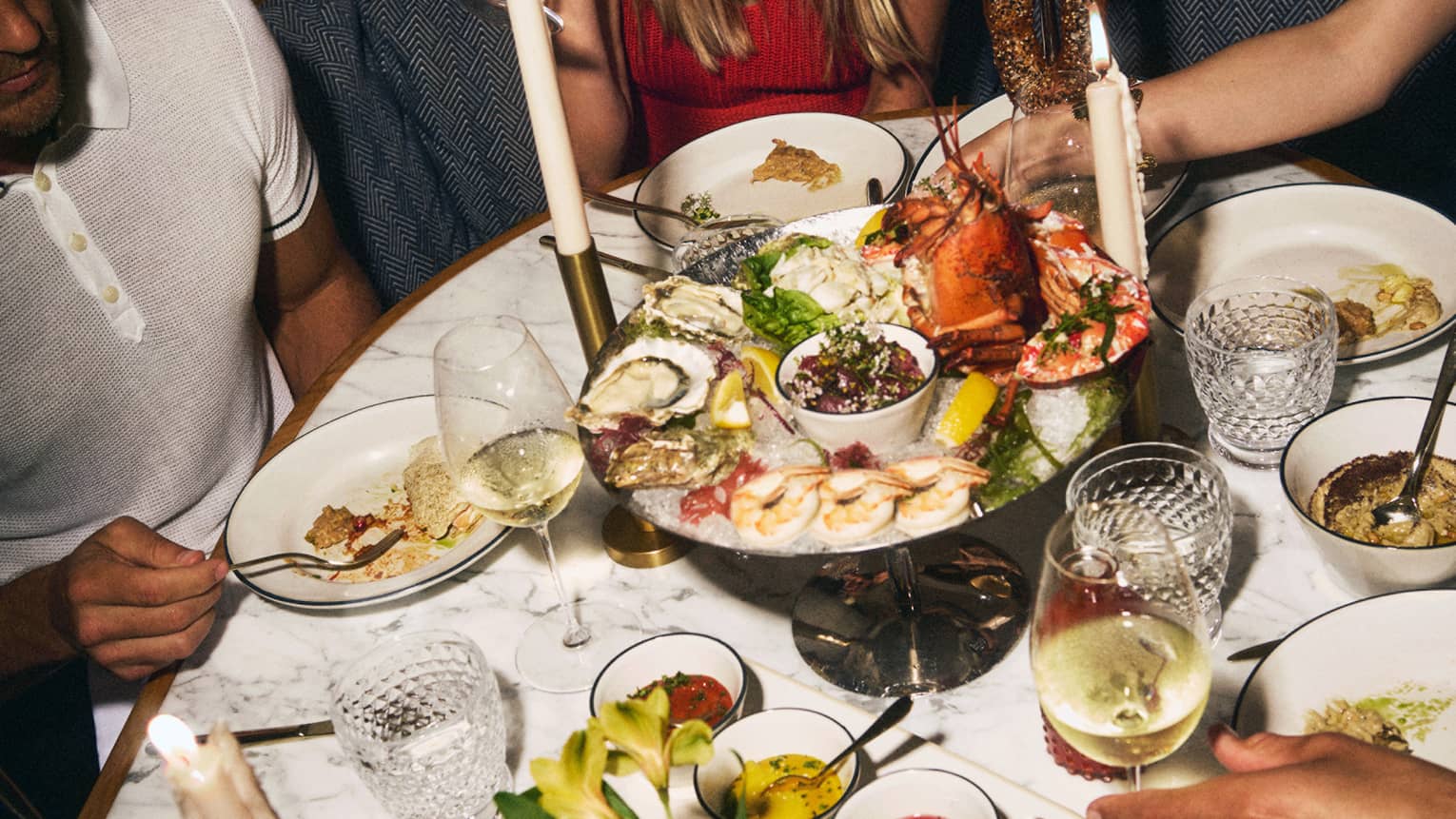 Oval table filled with large dinner spread including a seafood tray and more