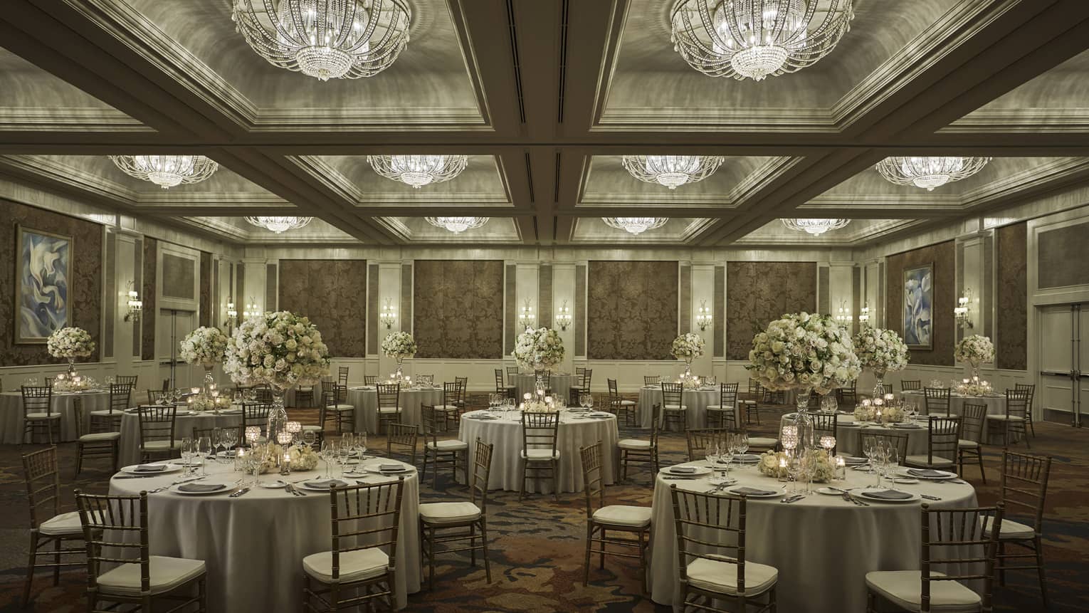 Round tables under crystal chandeliers in elegant Ocean Ballroom event space 