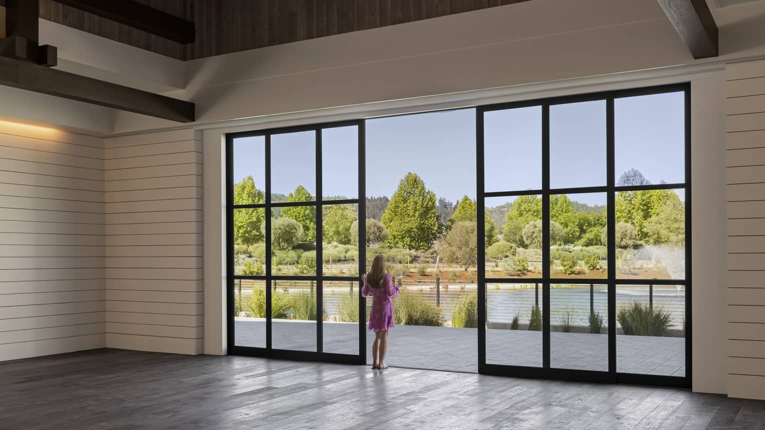Rustic venue space with multi-light modern chandelier, walk-out glass doors