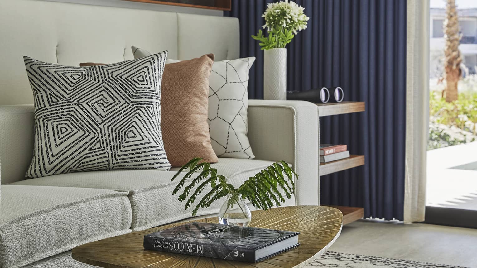 A coffee table with a large coffee book next to a beige sofa.
