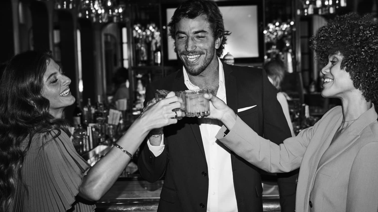 Three guests raising their glasses and smiling at one another.