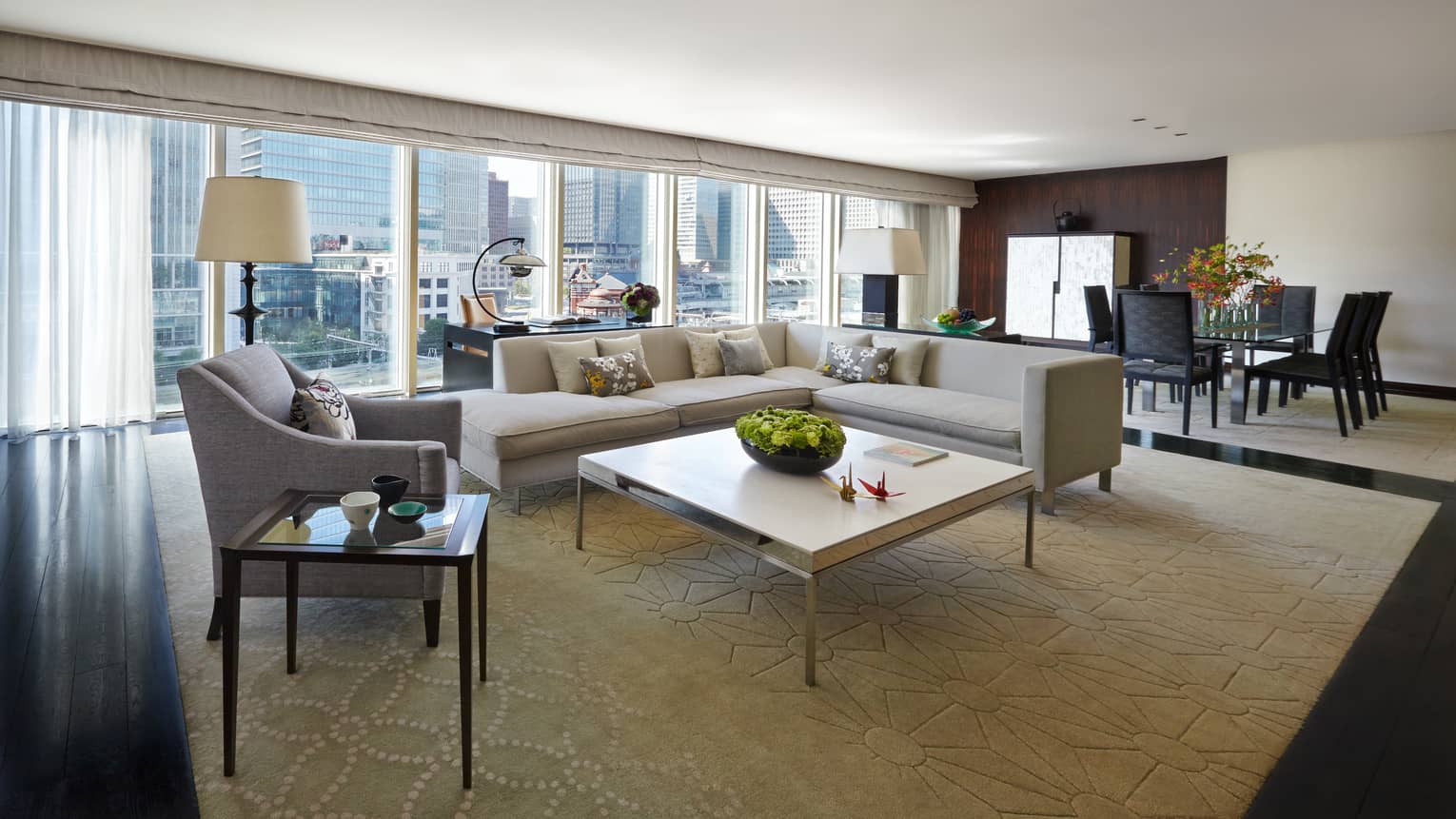 Chairman's Suite modern L-shaped grey sofa, armchair coffee table, wall of windows