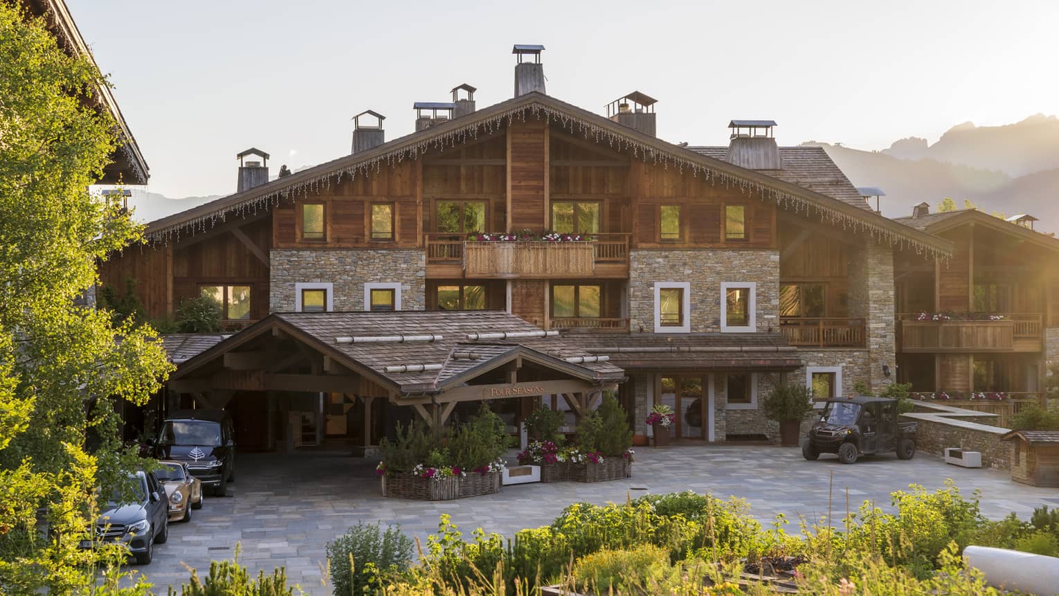 Large chalet surrounded by trees and with mountains in the background