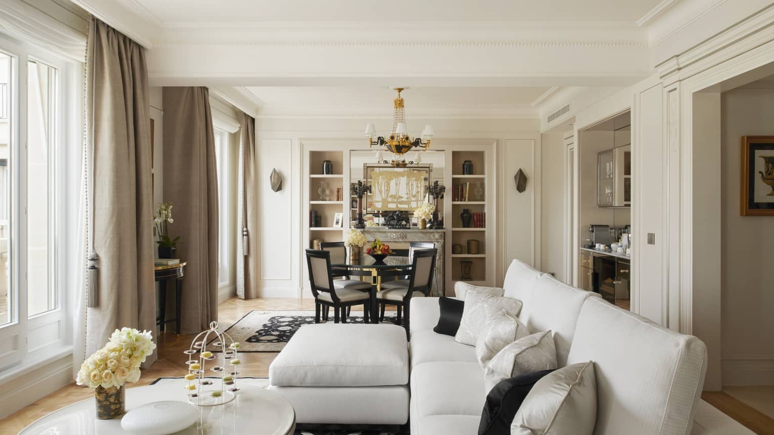 Parisian suite with white couch, coffee table, small table for four, black & white accents 