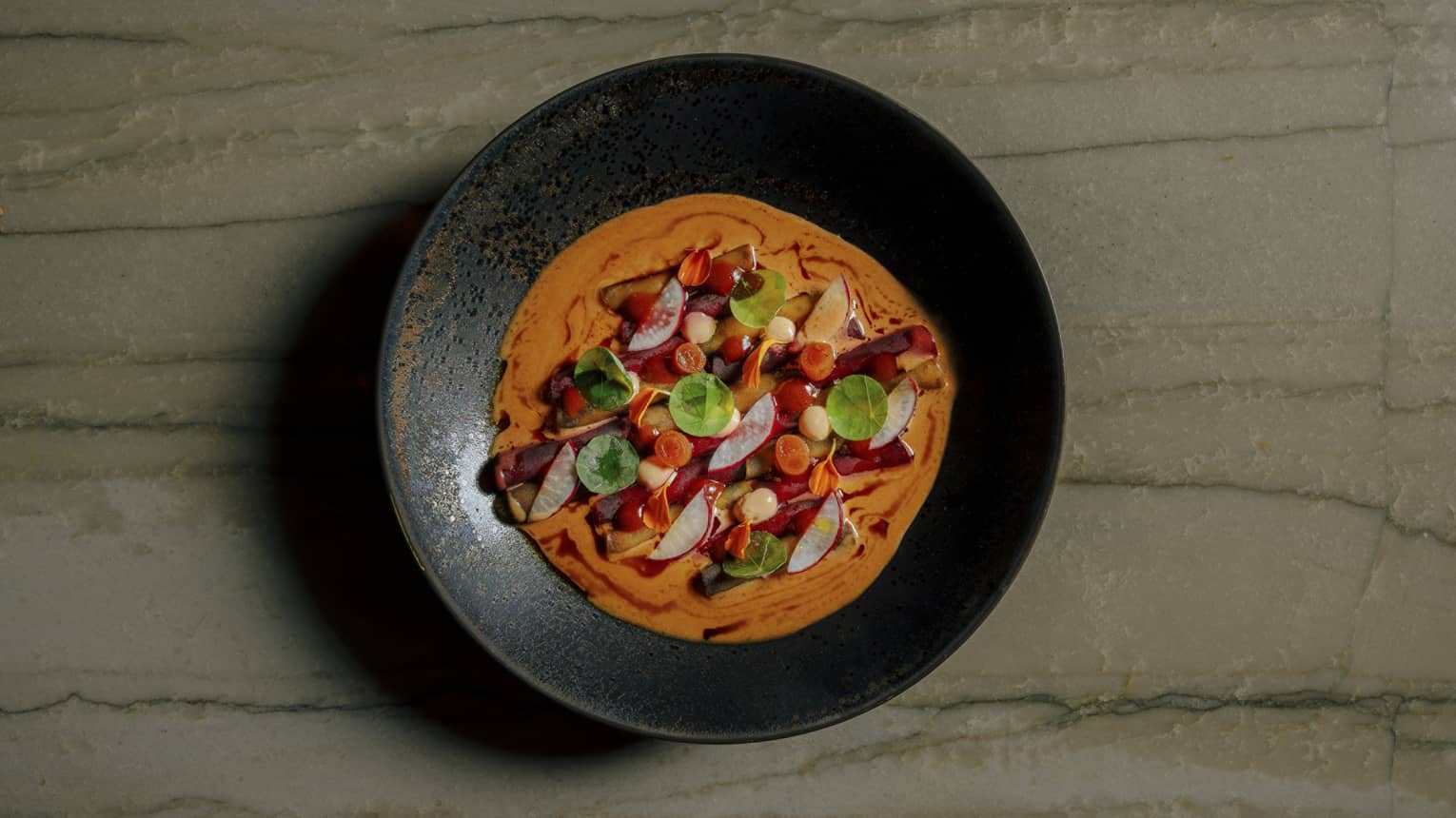 Colourful causa mosaic served in a black shallow bowl