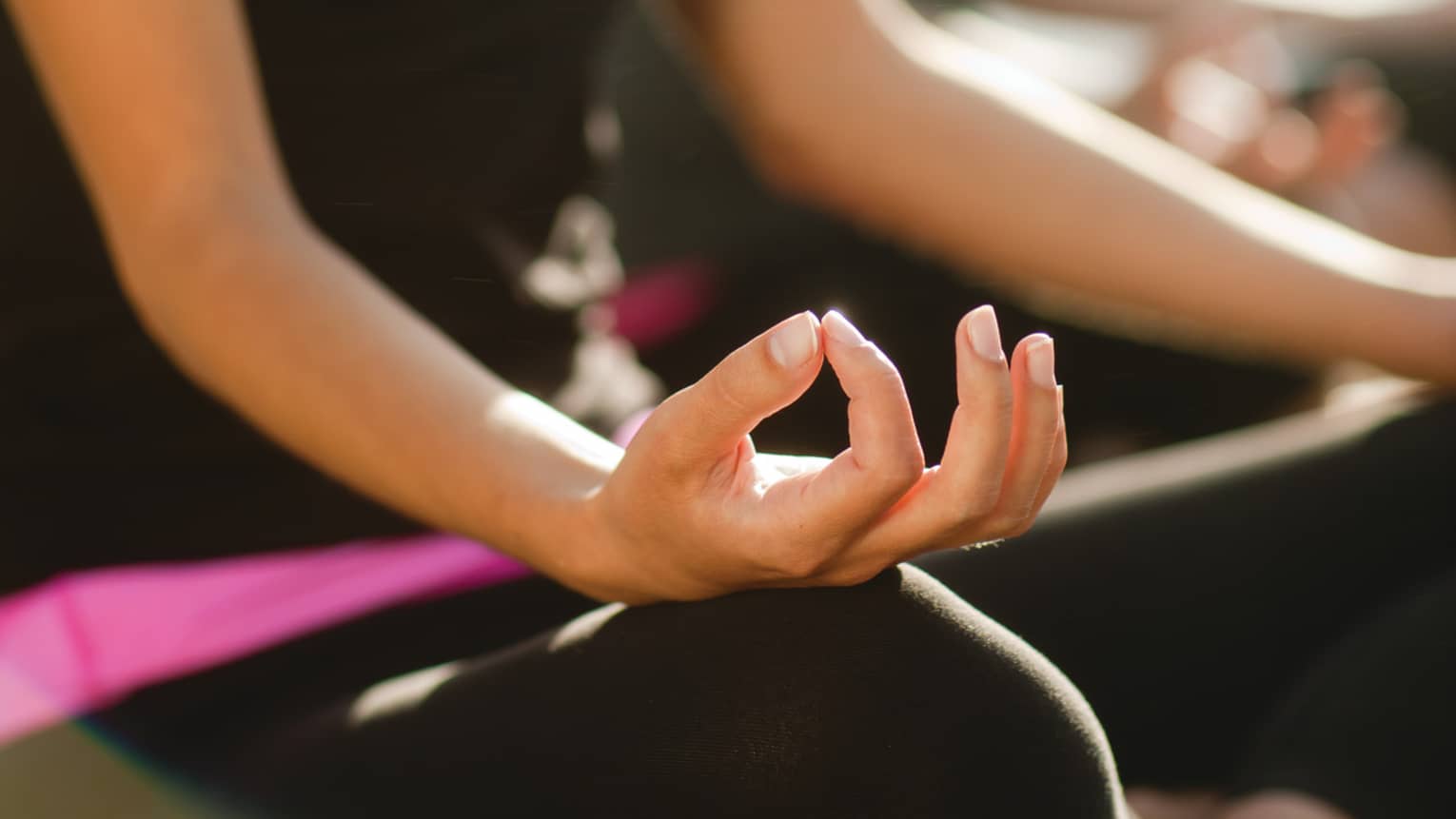 Two women sitting in a yoga pose.
