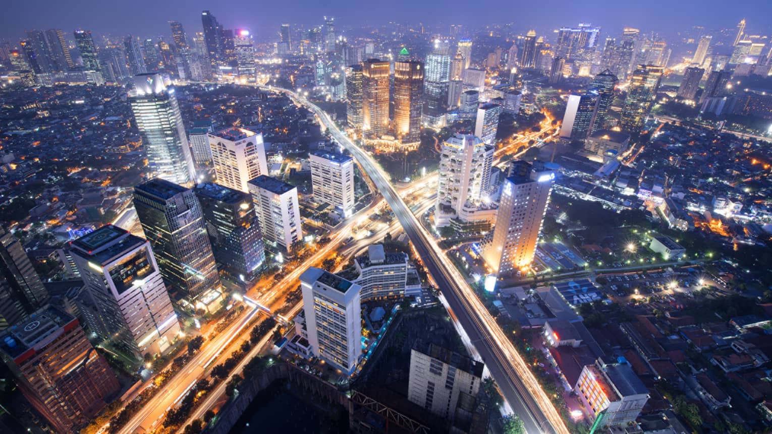 Aerial view of Jakarta city buildings and highways lit up at night
